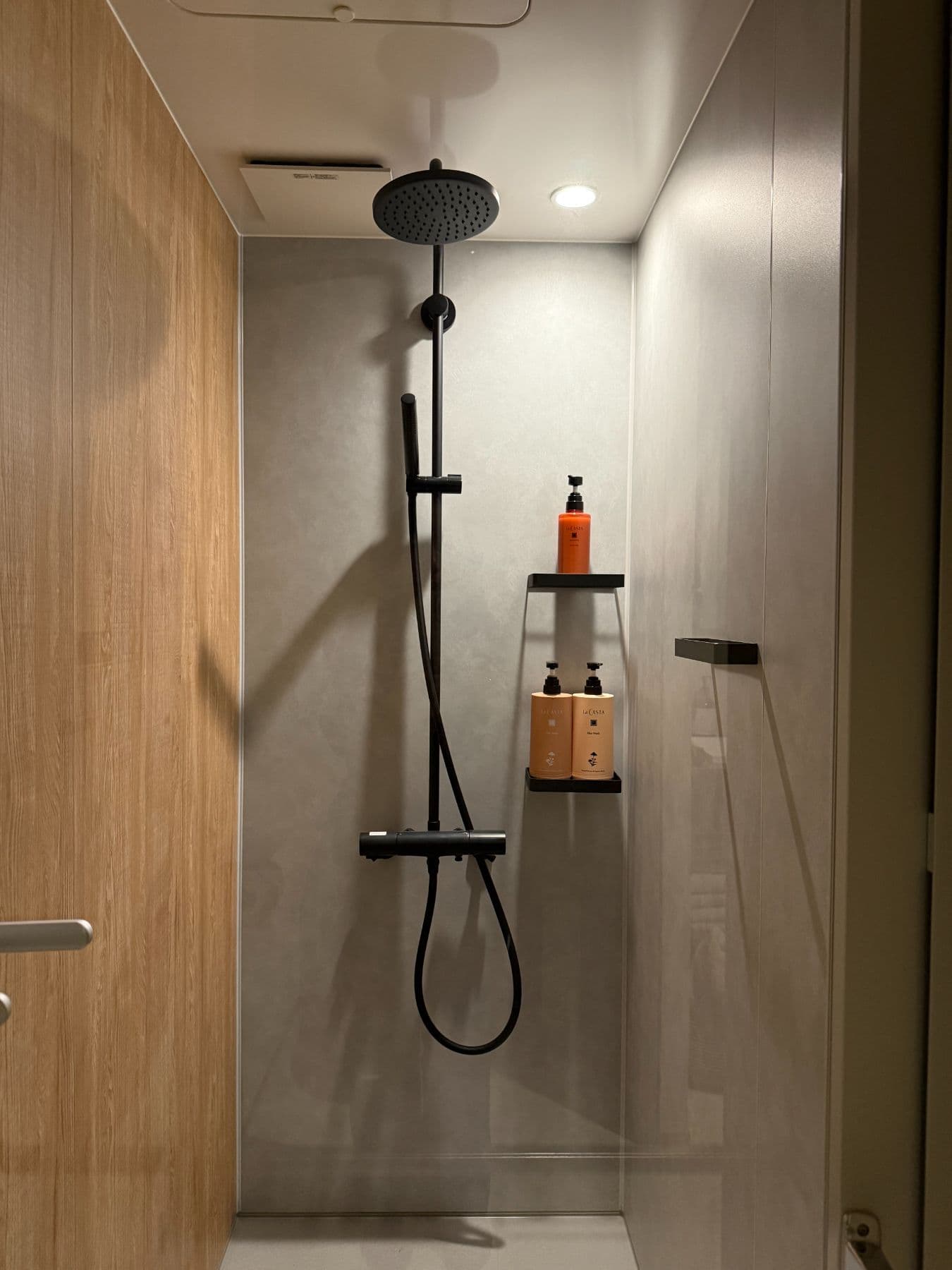 A shower room with a black rainfall shower.